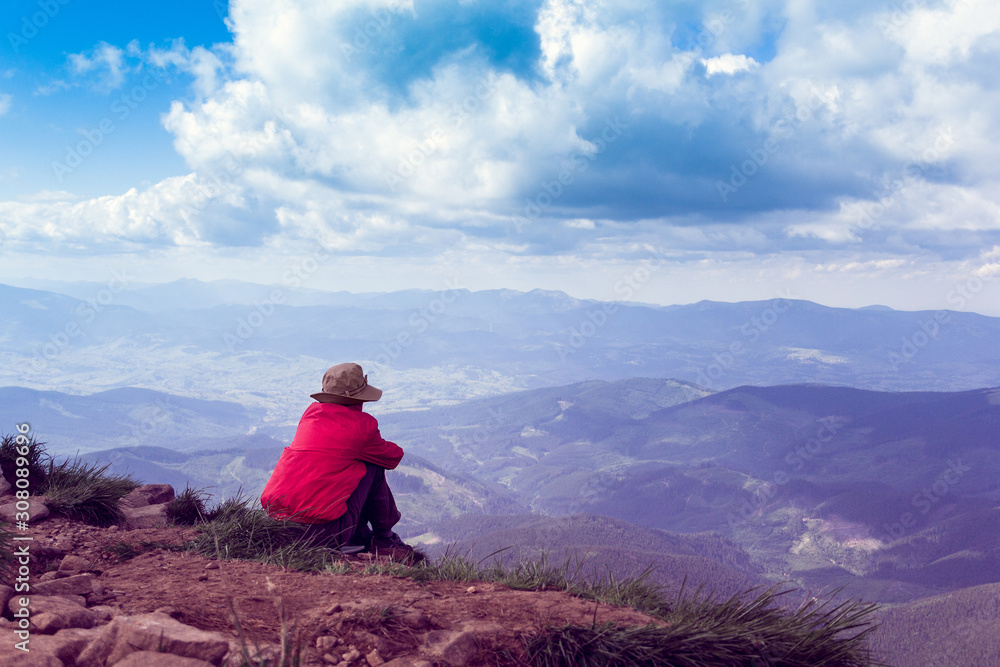 woman sits and looking afar to mountains