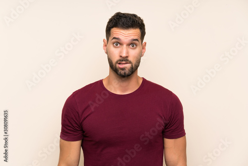 Handsome man over isolated background having doubts and with confuse face expression