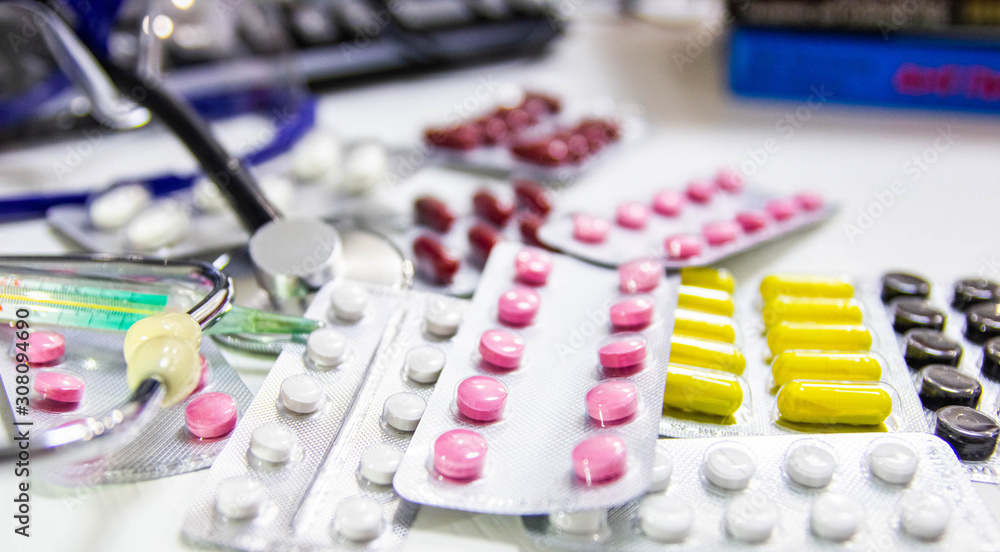 Medical and pharmaceutical concept, antibiotic pills stethoscope on the doctor’s desktop.