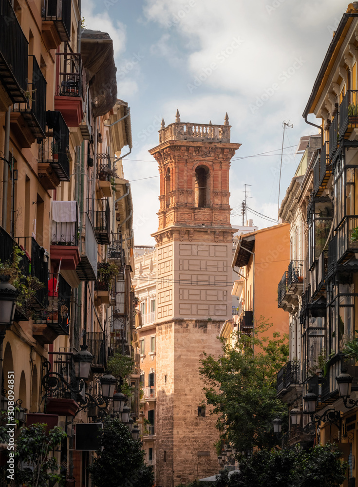Typical street of Valencia with a historic tower in the background, Spain