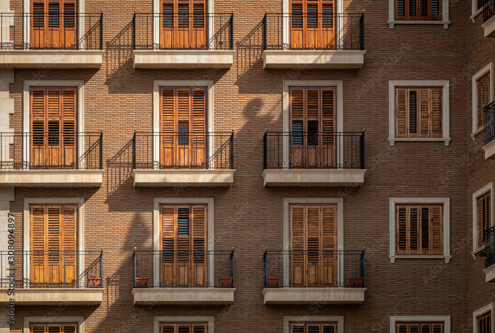 Typical facade of spanish old town of Valencia with beautiful balconies and windows.