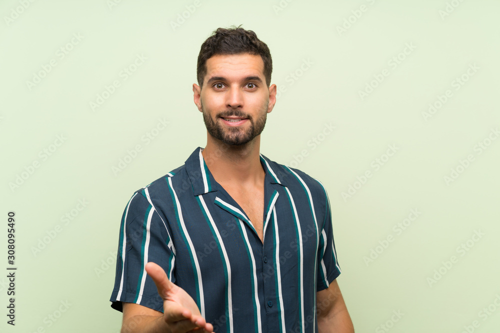 Handsome man over isolated background handshaking after good deal Handsome man over isolated background handshaking after good deal