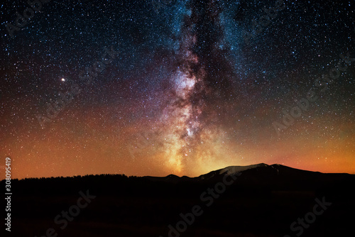 The bright milky way galaxy on the starrry sky over the mountains.  Night landsckape. Astronomical background.