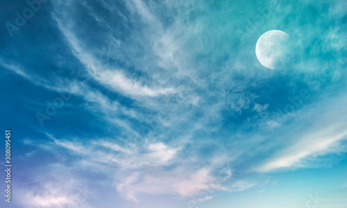 A beautiful sky and clouds is lit by a bright moon. Astronomical background. 