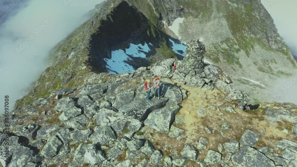 Family couple with baby on the top of mountain travel vacations outdoor mother and father hiking with child healthy lifestyle tourism in Norway aerial drone view Family couple with baby on the top of mountain travel vacations outdoor mother and father hiking with child healthy lifestyle tourism in Norway aerial drone view