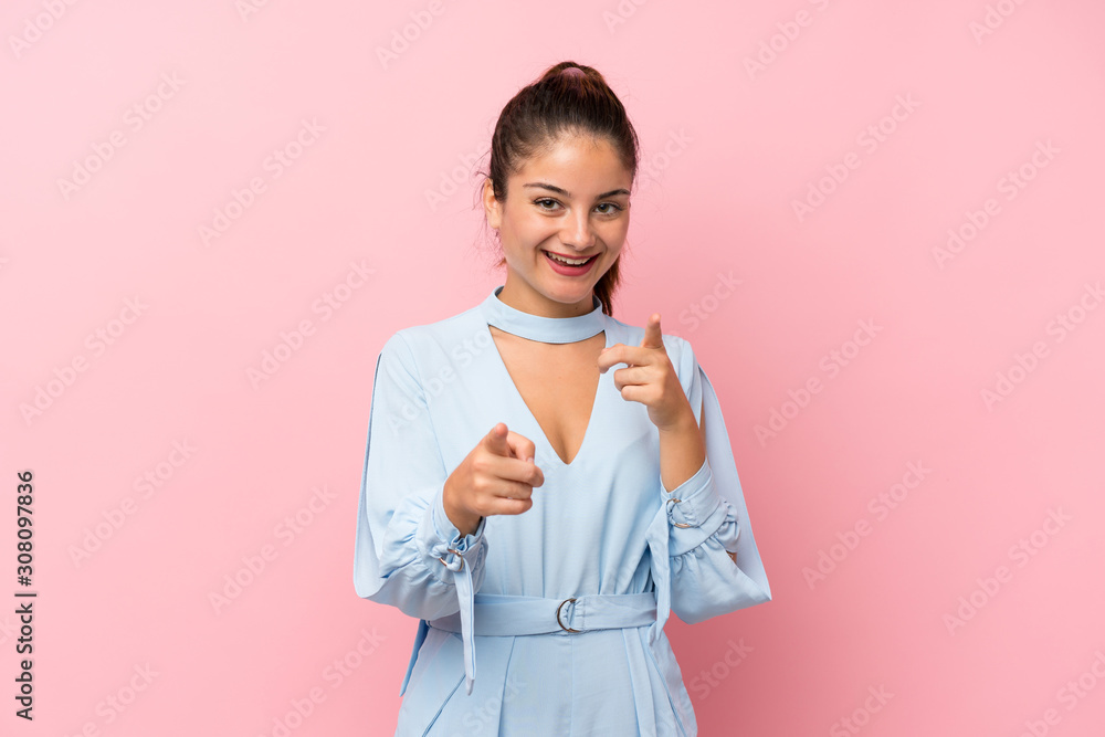 Young brunette girl over isolated pink background points finger at you Young brunette girl over isolated pink background points finger at you
