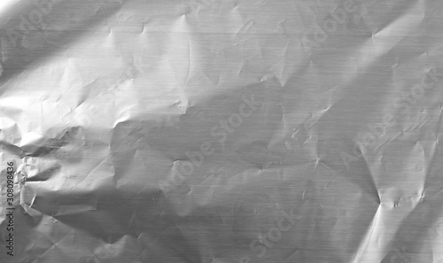 Crumpled silver aluminum foil background, abstract texture