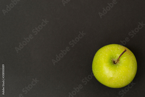 Green apple on a black background, chalk board, there is a place for text. Healthy eating concept.