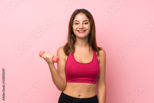 Young sport girl over isolated pink background making weightlifting © luismolinero