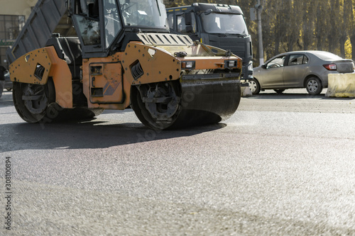 the road repair process, roller vehicle fix the highway in the urban city street © Mihail