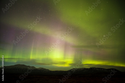 Auroras are the result of disturbances in the magnetosphere caused by solar wind. These disturbances are sometimes strong enough to alter the trajectories of charged particles in both solar wind.