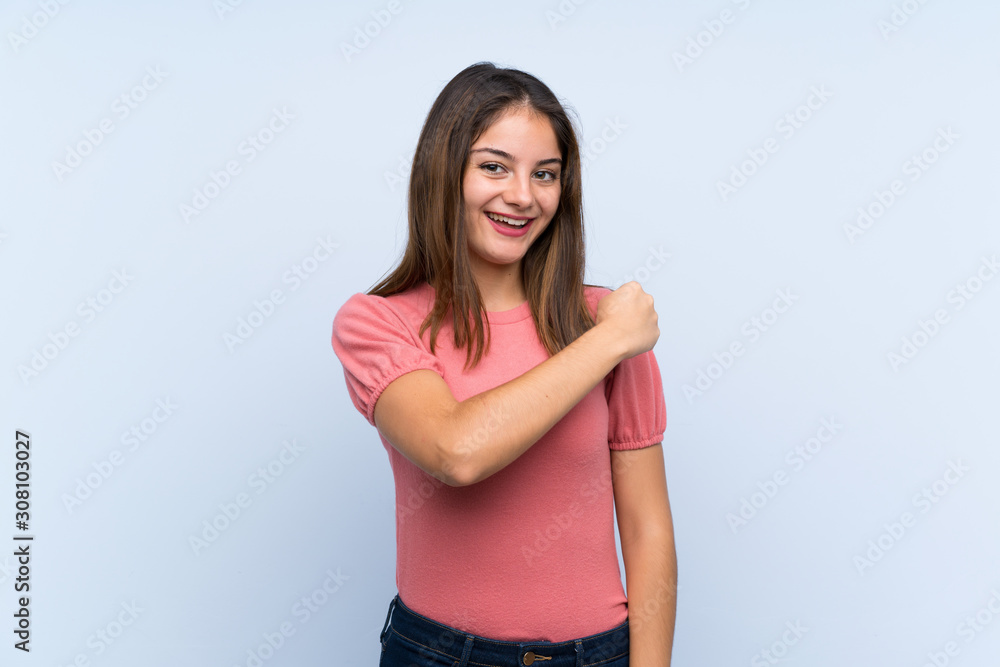Young brunette girl over isolated blue background celebrating a victory Young brunette girl over isolated blue background celebrating a victory