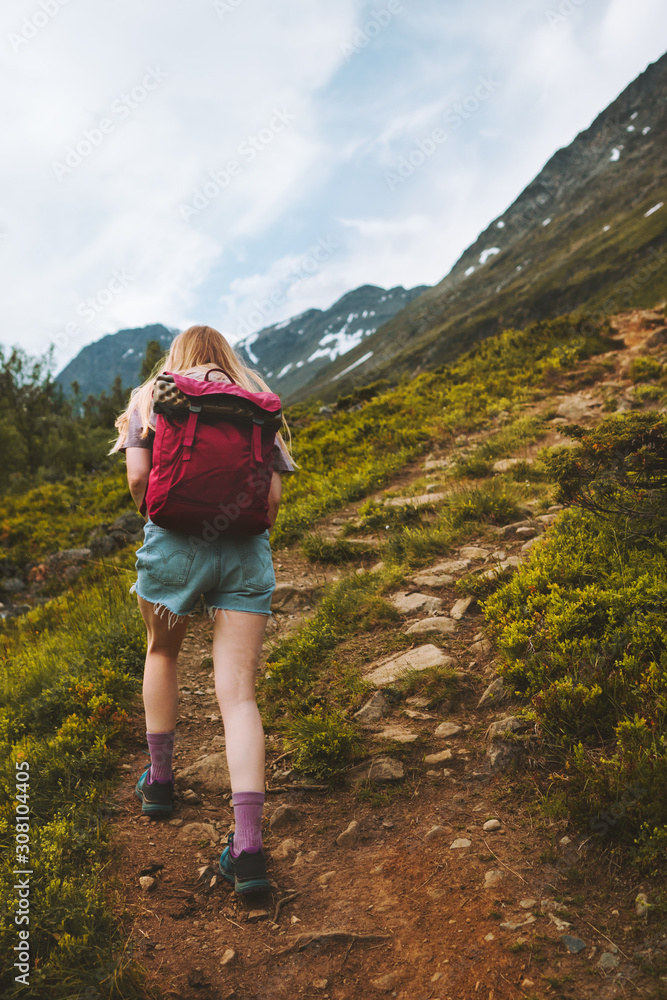 Fototapeta premium Woman traveling in mountains hiking with backpack adventure healthy lifestyle outdoor summer activity trekking in Norway
