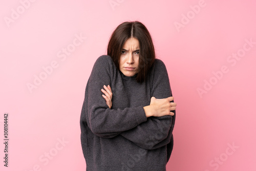 Billede på lærred Young woman over isolated pink background freezing