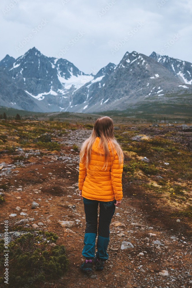 Traveler woman enjoying mountains view outdoor adventure hiking activity vacations alone healthy lifestyle woman exploring Lyngen Alps in Norway