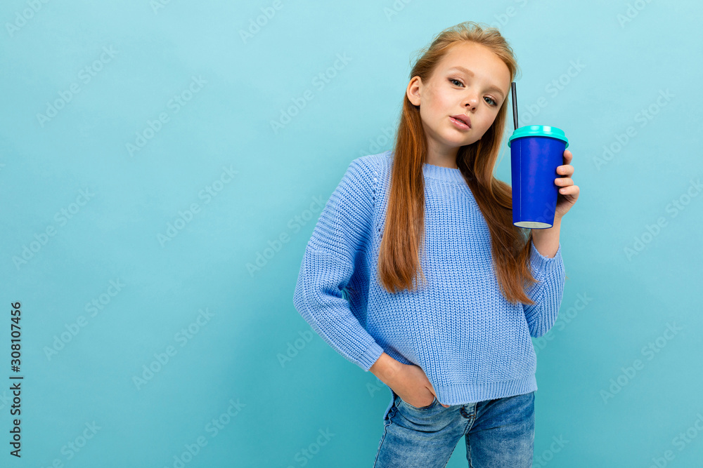 portrait of a european girl drinking holding a glass on a light blue background portrait of a european girl drinking holding a glass on a light blue background