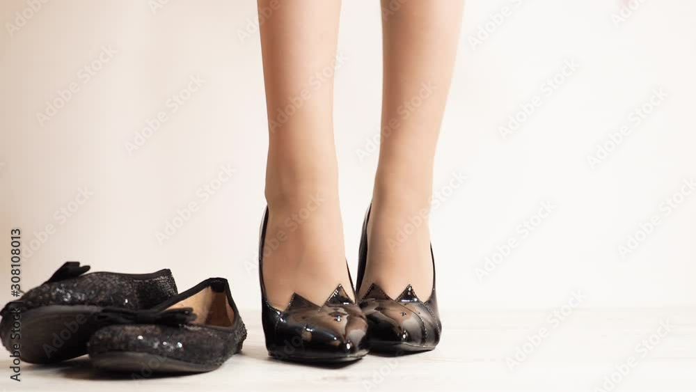 Putting on high heels shoes on white background. The girl prefers high-heeled shoes and discards ballet shoes. 4K Putting on high heels shoes on white background. The girl prefers high-heeled shoes and discards ballet shoes. 4K