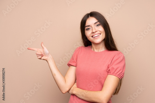 Young woman over isolated background pointing finger to the side © luismolinero
