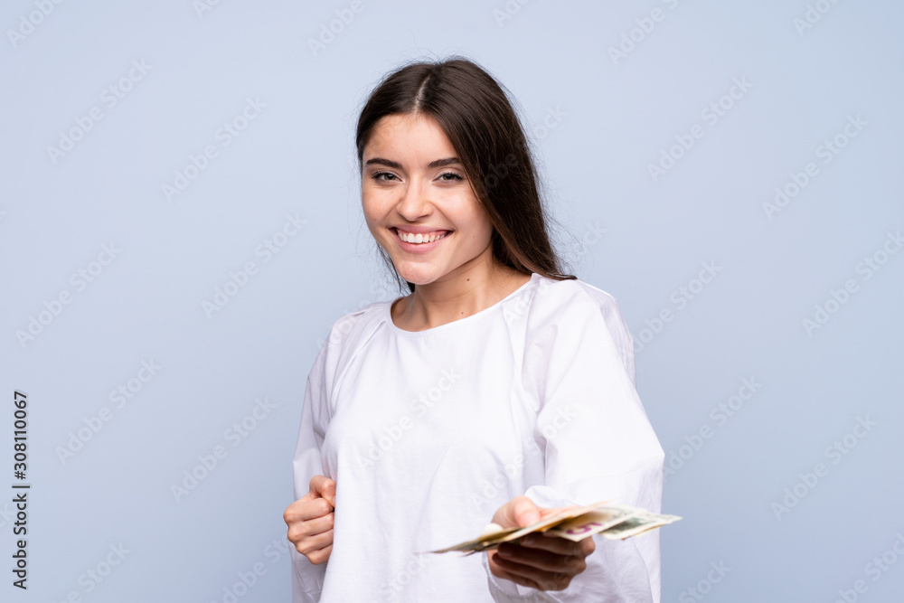 Young woman over isolated blue background taking a lot of money Young woman over isolated blue background taking a lot of money