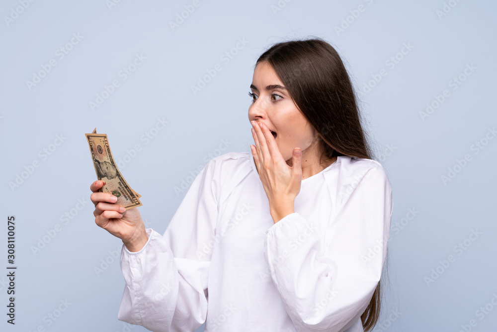 Young woman over isolated blue background taking a lot of money Young woman over isolated blue background taking a lot of money
