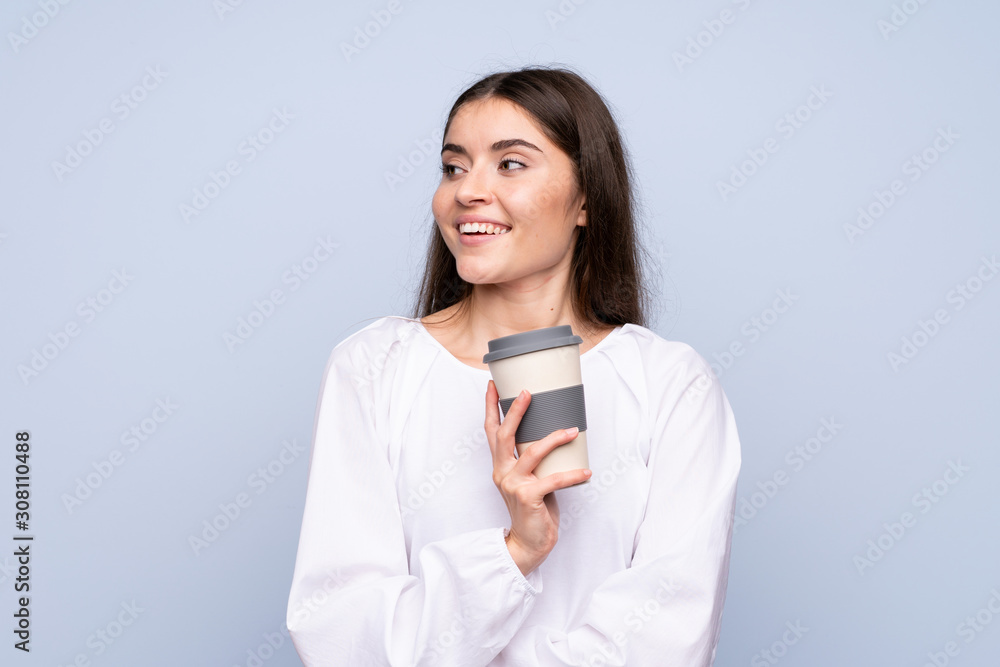 Young woman over isolated blue background holding coffee to take away Young woman over isolated blue background holding coffee to take away