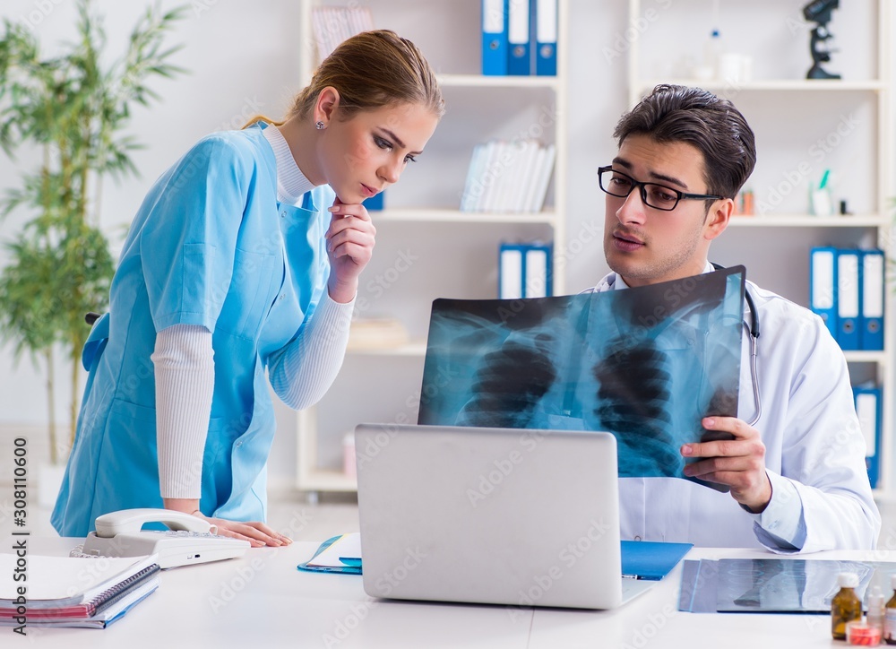 Two doctors examining x-ray images of patient for diagnosis Two doctors examining x-ray images of patient for diagnosis