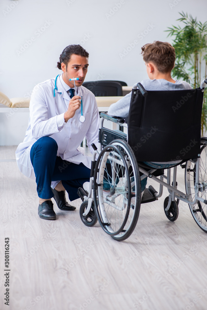 Young male doctor pediatrist and boy in wheel-chair Young male doctor pediatrist and boy in wheel-chair