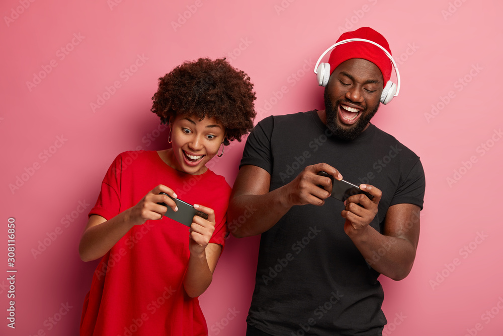 Happy Afro American girlfriend and boyfriend play games on