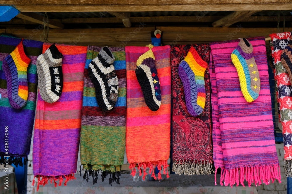  Hand-made wool gloves and scarves at a market stall in a Himalayan mountain village in Nepal. During trekking around Annapurna, Annapurna Circuit