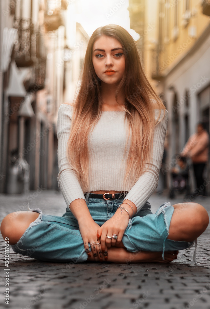 girl sitting on the ground in the street girl sitting on the ground in the street
