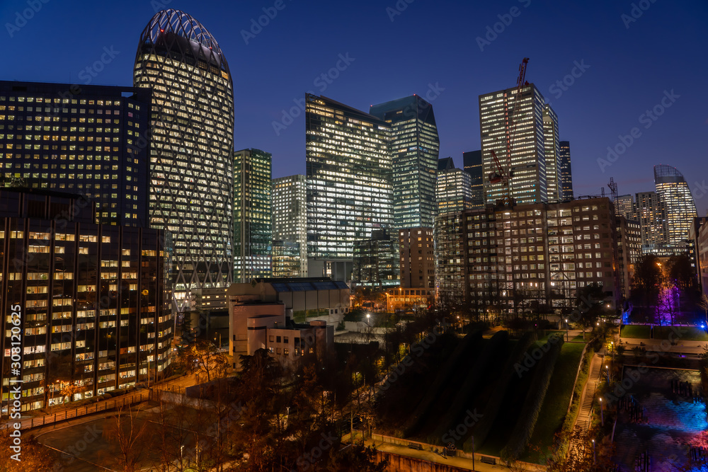 Fototapeta premium Paris La Defense CBD skyline with lights on after sunset with city streets lights on and Parc Diderot lights