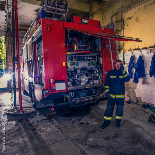 A firefighter repairing the fire engine in the fire station