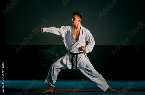 Male karate fighter in white kimono training