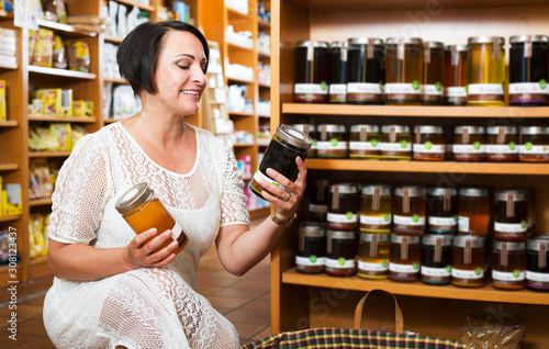 Woman choosing honey in store