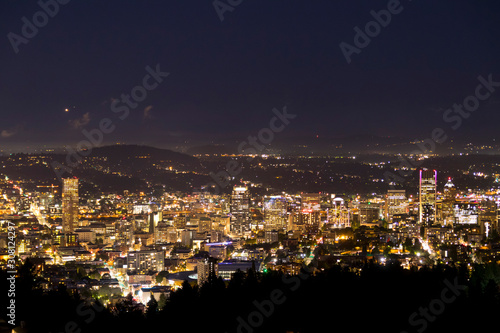 Portland Oregon city skyline at night and powerful lights illuminating highrise office buildings. City that never sleeps.