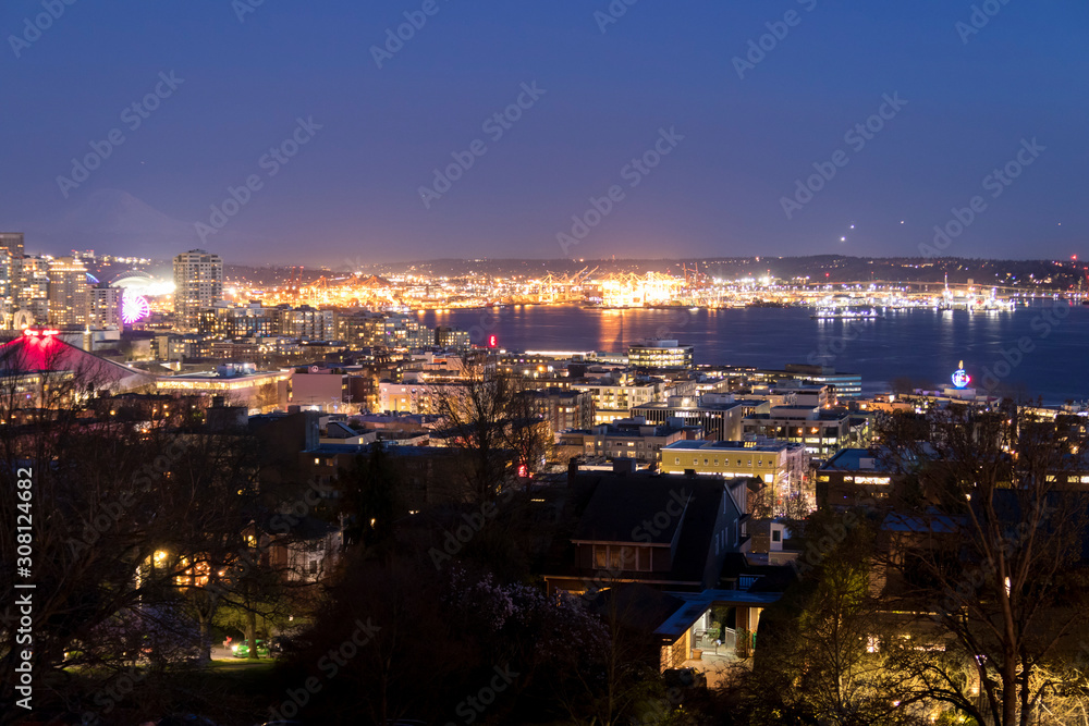 Seattle, Washington, United States. Harbor Island in the Elliott Bay and airplanes taking off and coming in to land nonstop from Seattle airport at night.