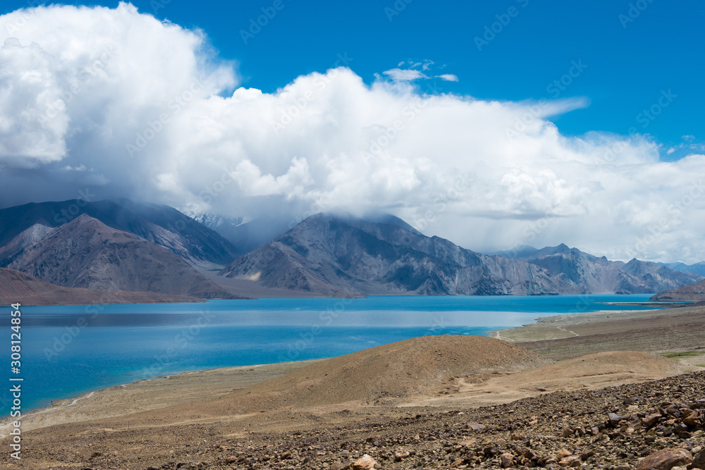 Obraz premium Ladakh, India - Aug 08 2019 - Pangong Lake view from Spangmik Village in Ladakh, Jammu and Kashmir, India. The Lake is an endorheic lake in the Himalayas situated at a height of about 4350m.