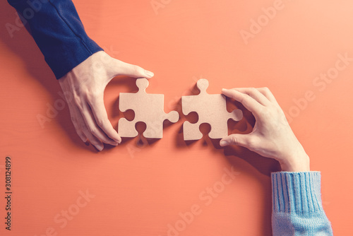 Two hands holding jigsaw, Concept for teamwork Building a success. photo