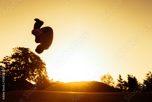 Young man silhouette performing a front flip