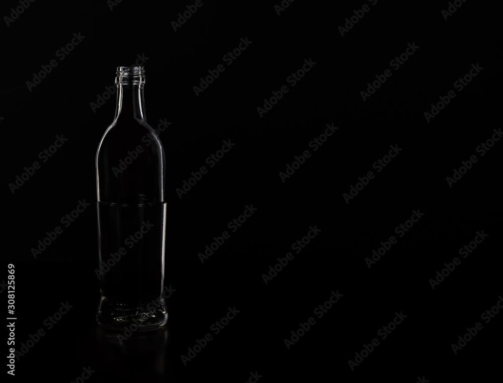 Silhouette of a glass bottle on a black background . Empty space for your lettering. Silhouette of a glass bottle on a black background . Empty space for your lettering.