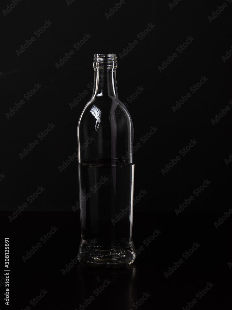 Silhouette of a glass bottle on a black background . Empty space for your lettering. Silhouette of a glass bottle on a black background . Empty space for your lettering.