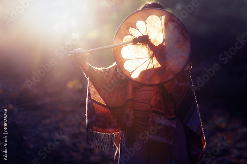 Fotografering beautiful shamanic girl playing on shaman frame drum in the nature