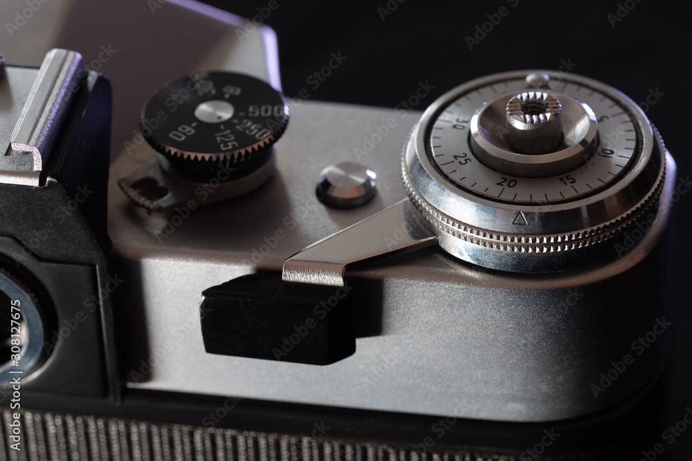 Fragment of a film camera close-up on a black background.