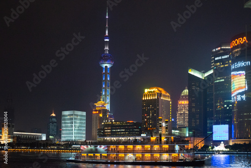 Nighttime in Shanghai at the Bund (riverside front) with landmarks from the opposite side of the river (PuDong) with pearl tower and all of them illuminated