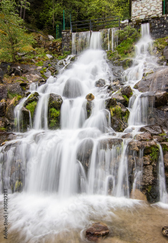 Fototapeta Naklejka Na Ścianę i Meble -  A small cascade waterfall, near a village of Encamp, Andorra. Located in the Pyrenees mountain