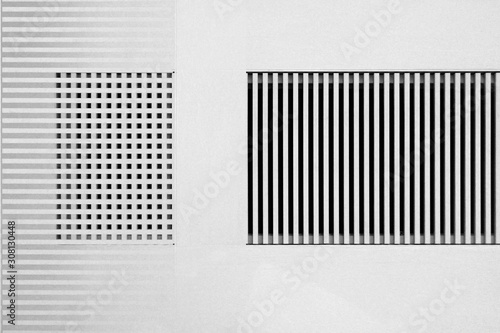 Lath structures of slots and cells. Stripes and checkers pattern in shades of gray. Interior design of architecture background against white stucco wall. Abstract geometric template.