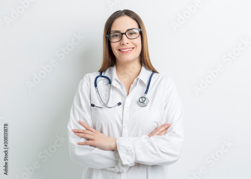 Portrait of a friendly young female professional doctor in a white medical coat.