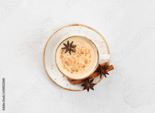 Indian Masala chai tea. Traditional Indian hot drink with milk and spices on white concrete background.
