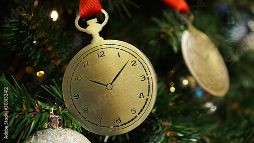 Christmas decorations on the Christmas tree. Iron clock.
