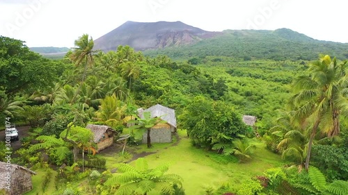 2019 - very good aerial over a jungle village on the island of Tanna reveals Mt. Yasur volcano in the distance, Vanuatu.